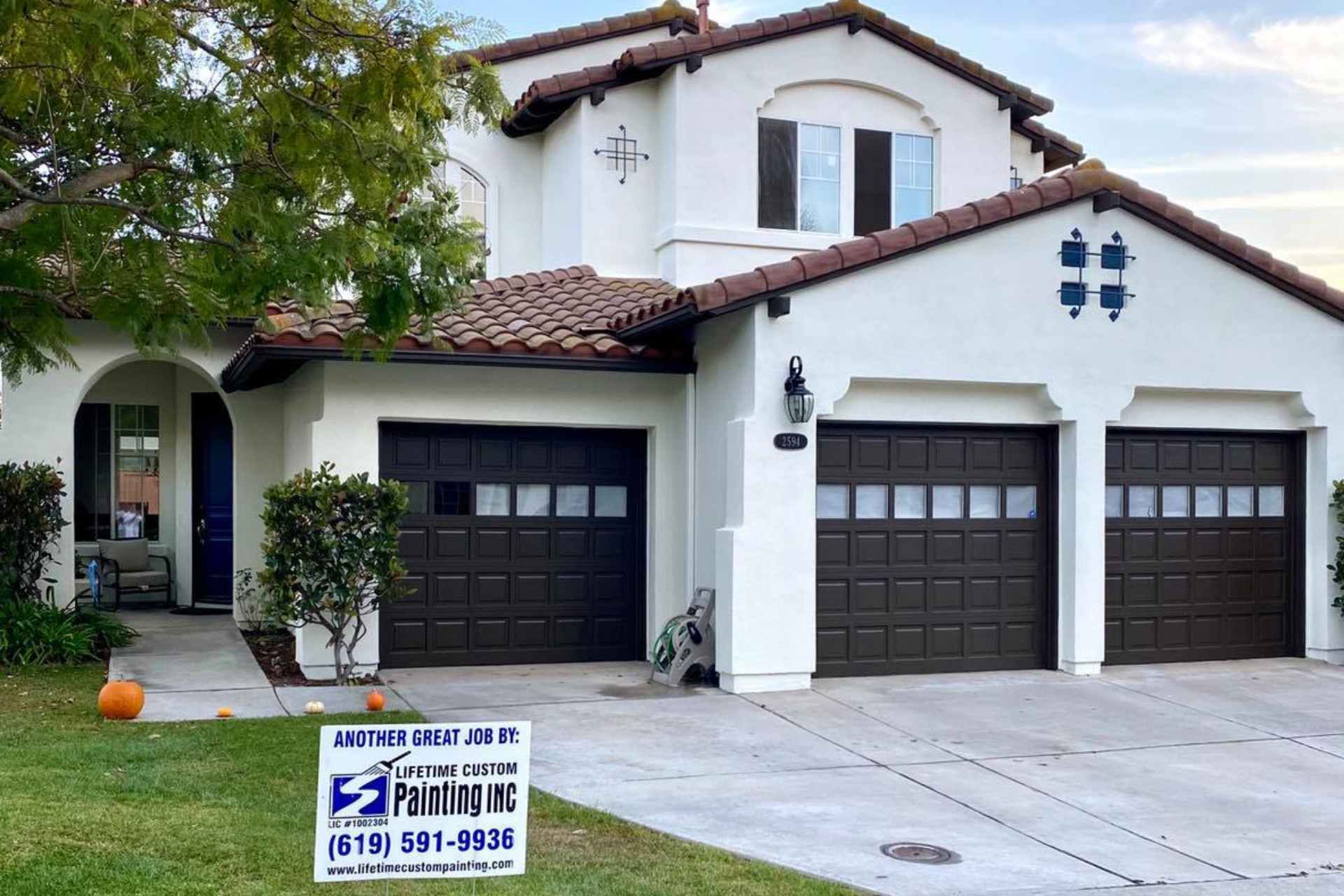 A beautifully painted house with a dark brown garage door.