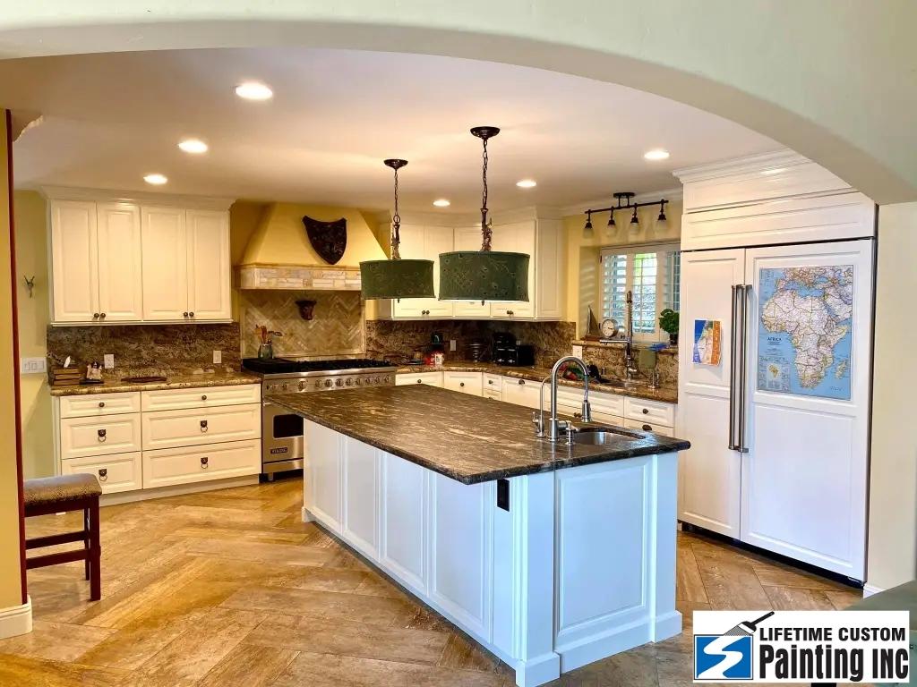 Fully furnished kitchen with white cabinets.